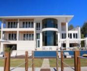 Enjoy ocean and sunset views from this 2014 Mashta Island estate on a 23,814 SqFt oversized lot with 138ft of water frontage. This custom-built home, inspired by Modern architect Richard Meier, features pure geometric lines and integrated open spaces with an emphasis on natural light. Unique features include a 3-story curved glass curtain wall, 14 skylights over a 27-ft high atrium, NanaWall folding glass doors, elevator, gym, dock, staff quarters, 4-car garage, generator and smart home technolo