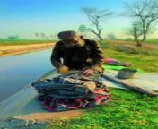 In this video, an elderly man is washing clothes on the banks of the canal. It is a very difficult time.